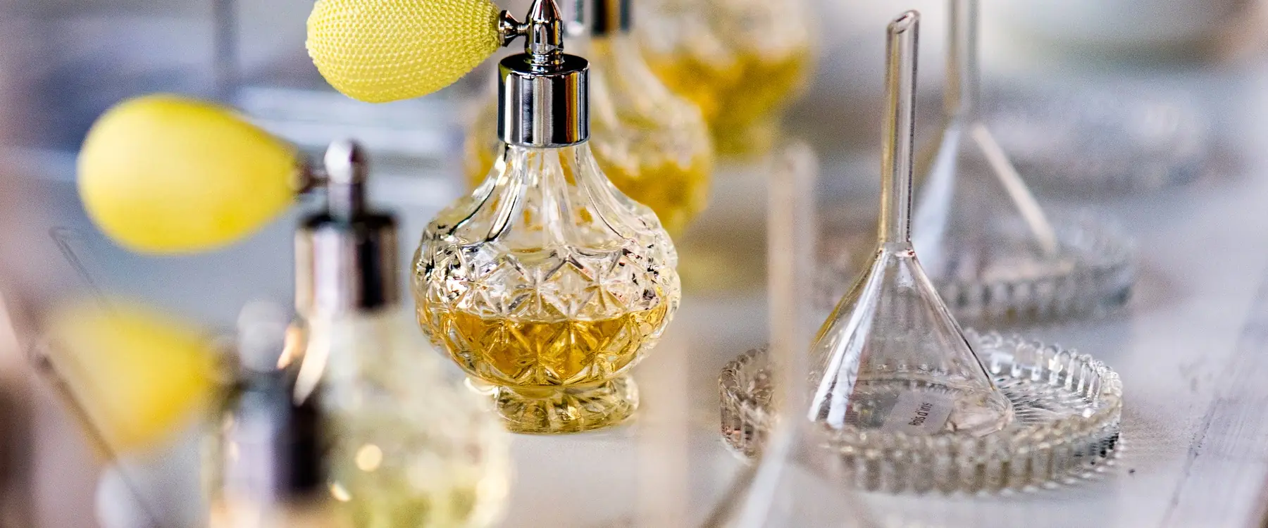 Vaporisateurs vintage et entonnoirs en verre alignés sur le comptoir du bar à parfum