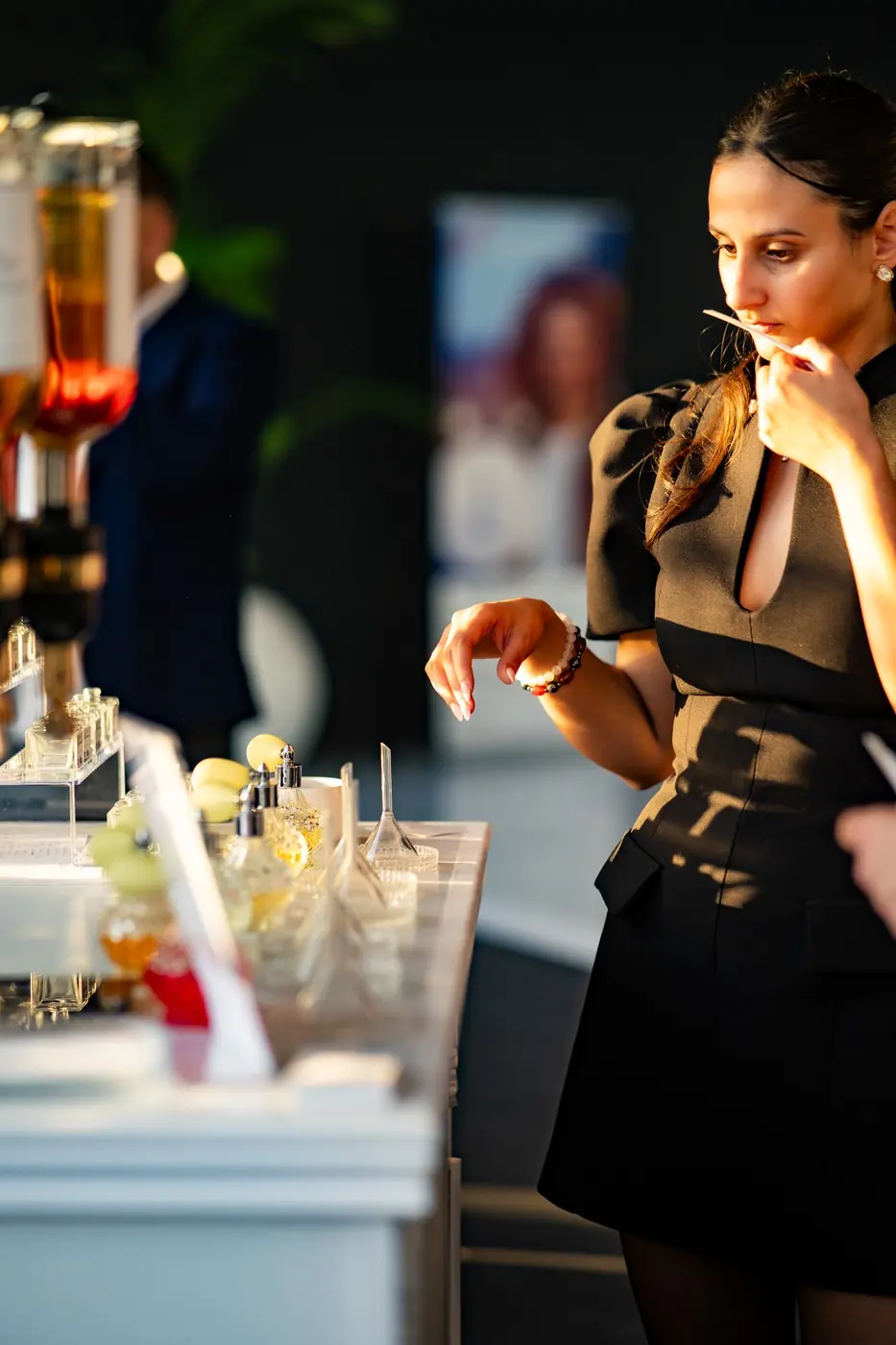 Invitée découvrant une fragrance au bar à parfum lors d’une soirée VIP